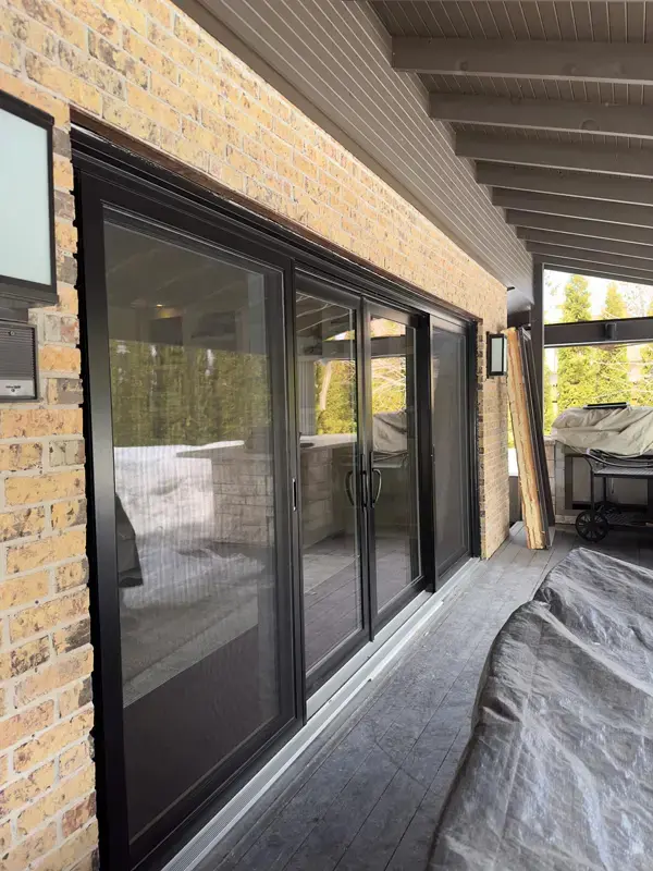 Black sliding patio doors on Ottawa brick home exterior